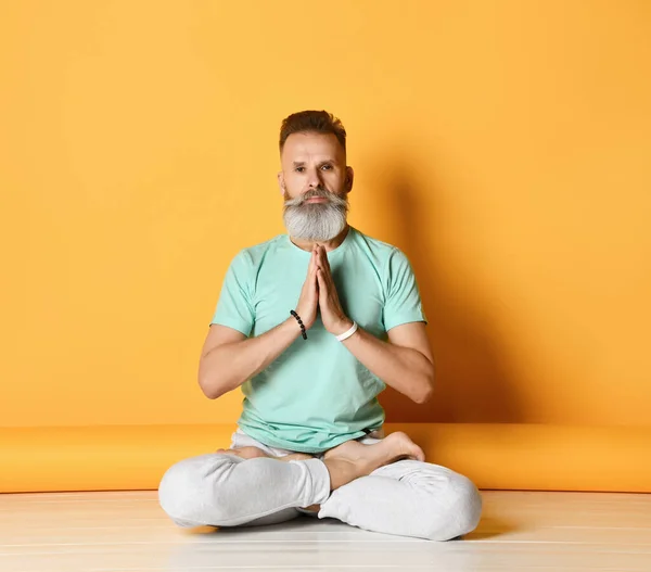 Gammal man i lotus yoga padmasana pose studio skott — Stockfoto