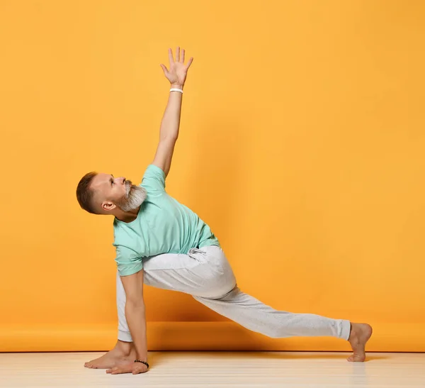 Un uomo. Uomo che fa yoga su uno sfondo giallo — Foto Stock