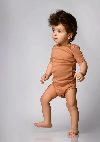 Cute Curly Baby Beige Bodysuit Makes His First Steps Looks — Stock Photo, Image