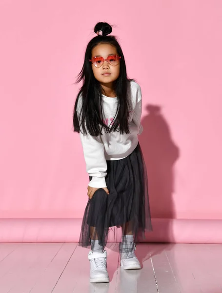 Retrato de una pequeña modelo coreana que está posando profesionalmente sobre un fondo rosa. — Foto de Stock