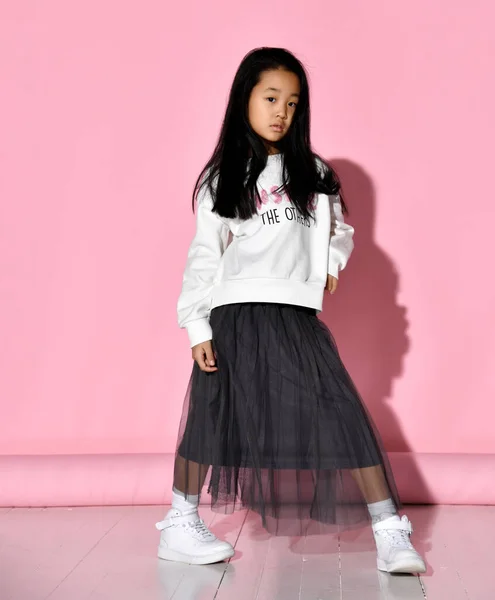 白いセーター、チュールスカート、スニーカー、赤いメガネを身に着けているスタイリッシュな韓国の女の子の肖像画. — ストック写真