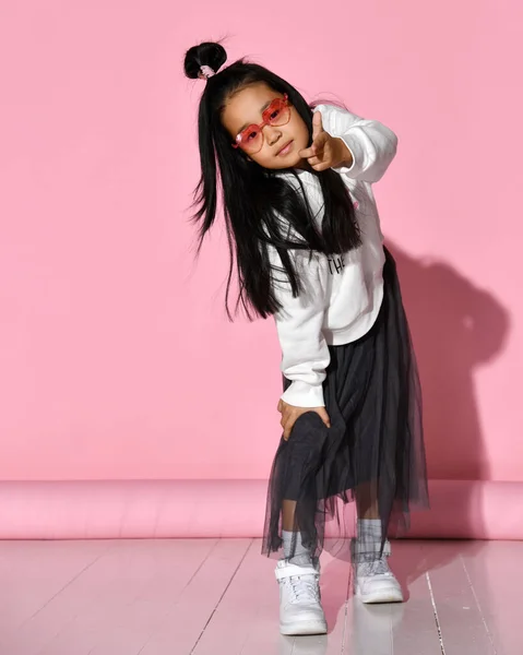 Retrato de una pequeña modelo coreana que está posando profesionalmente sobre un fondo rosa. — Foto de Stock