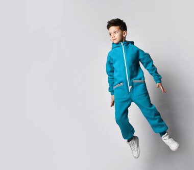 Sıcak eşofmanlı çocuk izole stüdyo çekimlerinde zıplıyor.