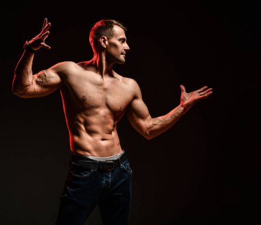 Atletik vücutlu seksi adam kaslarını gösteriyor.