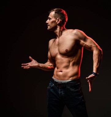 Atletik vücutlu seksi adam kaslarını gösteriyor.