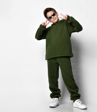 Eşofmanlı ve beyaz arka planda beyaz spor ayakkabılı aktif havalı çocuk. Modern bir çocuk için spor anlayışı ve sağlıklı bir yaşam tarzı..