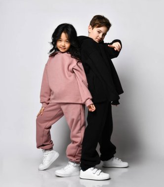 Çocuklar erkek ve kız stüdyoda arka planda poz veriyorlar..