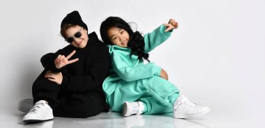 Modaya uygun ırklar arası sportif erkek ve kız zafer işareti gösteriyor.