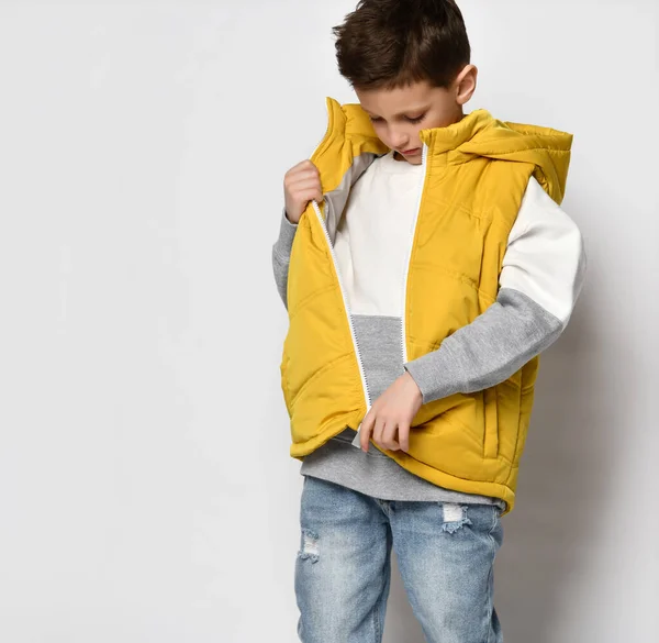 Модний хлопчик-підліток позує в осінньому жилеті, ізольований на світлі — стокове фото