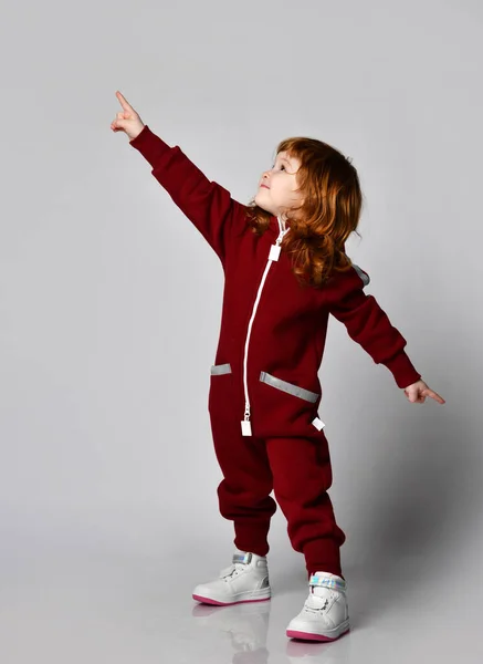 Gioiosa bambina dai capelli rossi in tuta sportiva calda vista laterale ritratto — Foto Stock