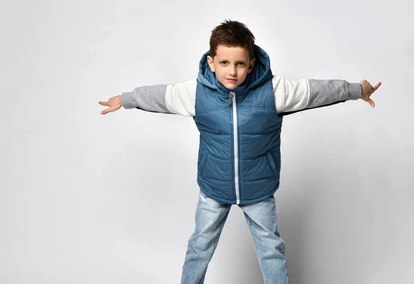 Adolescente sorrindo em um colete acolchoado ou jaqueta, pronto para passar férias de inverno e férias no conforto e calor, apresentando o produto, espaço de cópia — Fotografia de Stock