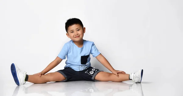 アジアの男の子で夏のtシャツとショートパンツで床のスタジオショット — ストック写真