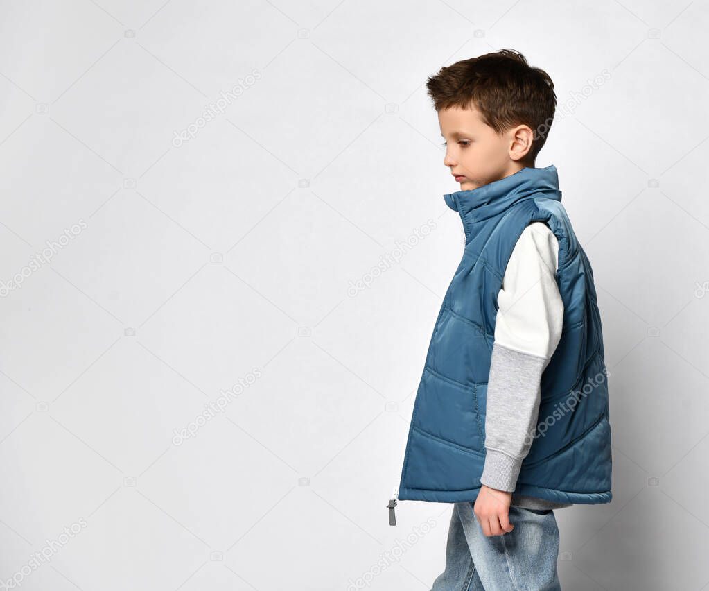 smiling teenager in a quilted or down jacket vest, ready to spend winter holidays and vacations in comfort and warmth, presenting the product, copy space