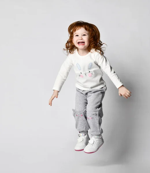 Full length portret van een vrolijk schattig meisje springen op een witte achtergrond — Stockfoto