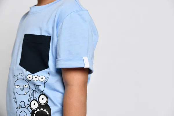 Detailní záběr dětského trička s potiskem monstra a modrou náprsní kapsou — Stock fotografie