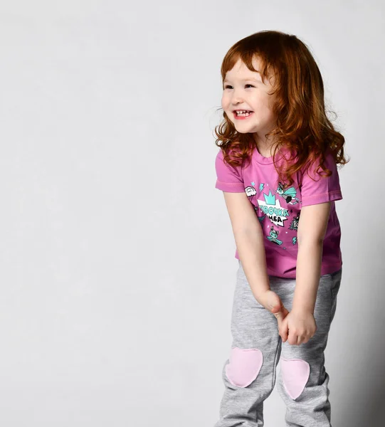 Timido sorridente cutie sorridente piccola bambina in studio di abbigliamento sportivo girato — Foto Stock