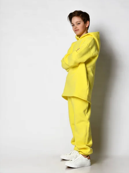 Retrato de cuerpo entero de un adolescente vestido con un traje deportivo amarillo brillante. —  Fotos de Stock