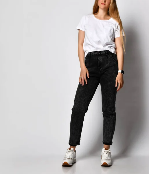 Studio skott av oigenkännlig snygg ung kvinna i svarta jeans och vit t-shirt. — Stockfoto