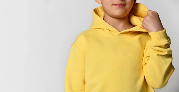어린 소년의 옷을 입은 노란 스포츠 훌 디를 자세히 살펴보 십시오. 하얀 배경. — 스톡 사진