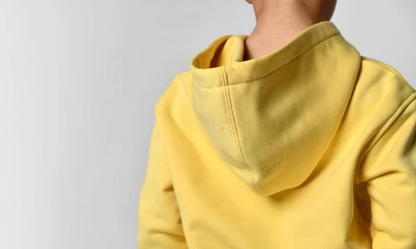 Close-up view from the back, focus on the hood of the boys yellow sweater. — Stock Photo, Image