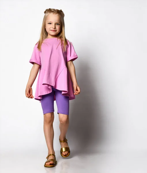 Gelukkig schattig klein meisje in jurk glimlachen en lopen over witte achtergrond — Stockfoto