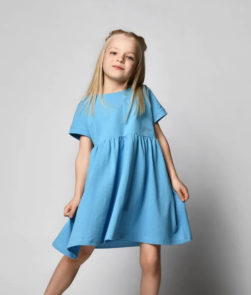 Studio portret van een schattig mooi meisje in een blauwe zomer jurk op een witte achtergrond. — Stockfoto
