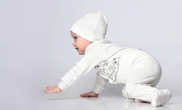 Vista lateral de uma criança bonita de 10 meses rastejando no corpo leve e calcinha em um chapéu agradável — Fotografia de Stock