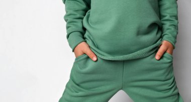 Cropped studio shot with child hand in pocket of sportswear clipart