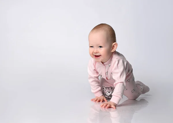 Söt spädbarn i rosa body suit Kostym med strumpor lära krypa och gå på ljusa studio bakgrund. — Stockfoto