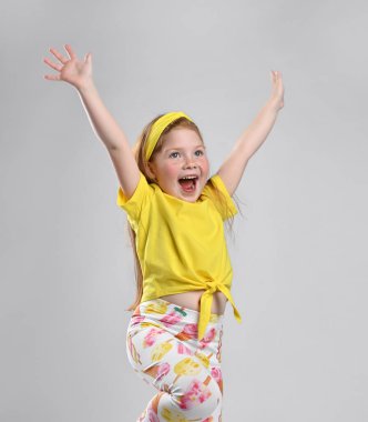 Süper mutlu küçük kızıl saçlı kız sevinir, yüksek sesle bağırır, mutlu hisseder, stüdyo fotoğrafı çekilir.