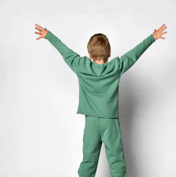 Vista posterior de niño lindo niño de pie extendiendo los brazos levantados — Foto de Stock
