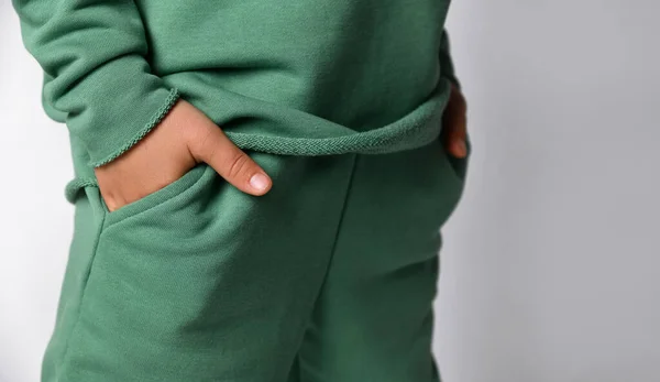 Estudio recortado plano con niño mano en bolsillo de ropa deportiva — Foto de Stock