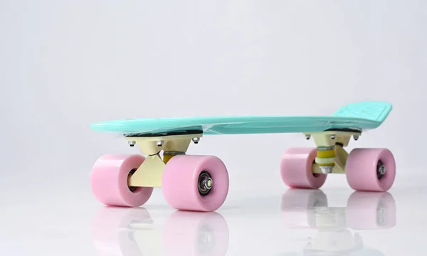 Mint plastic skateboard met roze wielen. — Stockfoto