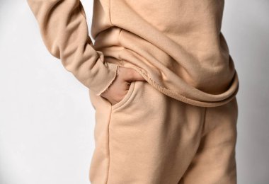 Kırpılmış stüdyo resmi, çocuk eli ve spor kıyafetleri cebinde.