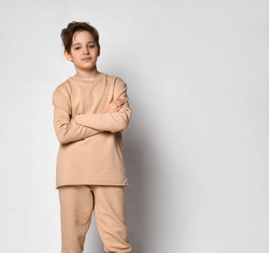 Havalı küçük çocuk beyaz arka planda tek başına duruyor.