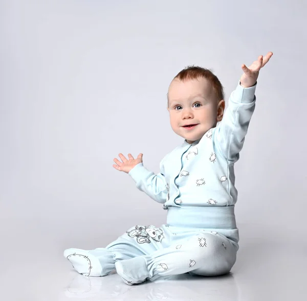 스튜디오 바닥에 앉아 있는 작고 귀여운 아기가 여름 면 양복을 입고 밝은 배경의 면으로 된 양복을 입고 있었습니다. 고립됨 — 스톡 사진