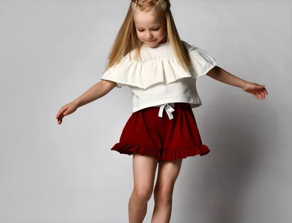 Ξανθιά κοπέλα χορεύει και στροβιλίζεται σε λευκό φόντο. — Φωτογραφία Αρχείου