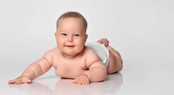 Bebê de 6 meses de idade está em uma fralda em um fundo leve — Fotografia de Stock