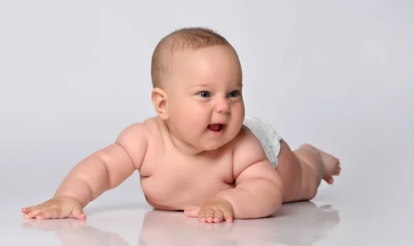 Bebê de 6 meses de idade está em uma fralda em um fundo leve — Fotografia de Stock