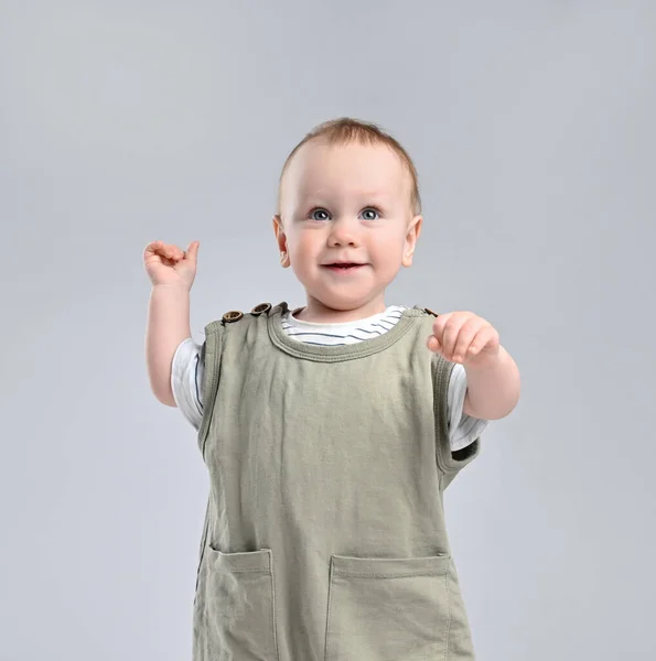 Portrait of a cute baby 12 months old in a green cotton jumpsuit with short sleeves. posing on a light studio background — Stock Photo, Image