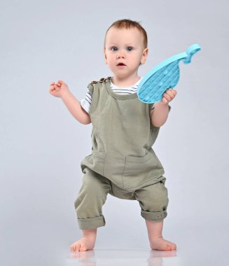 Oyuncak kullanan meraklı küçük çocuk beyaz arka planda izole edilmiş.