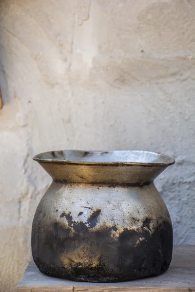 Eski pot, beyaz duvarlar, beton zemin, eski, siyah. — Stok fotoğraf