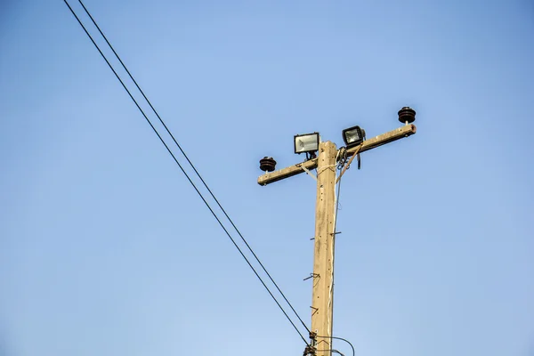 Postes, alambre, cemento. Bombillas, lámparas, cielo . — Foto de Stock