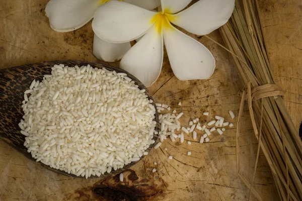 Drewniana łyżka ryżu, drewniane podłogi, ryż brązowy, jaśminowa, powierzchni. — Zdjęcie stockowe