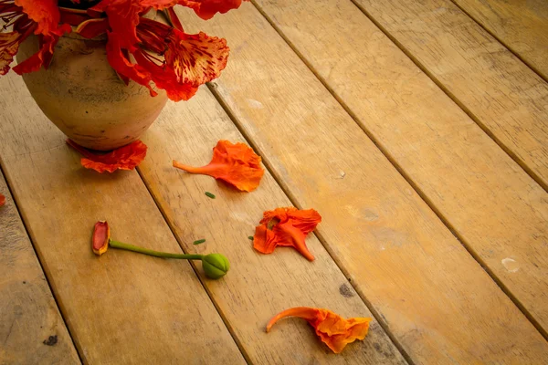 古い木製のテーブルの上のオレンジ色の花. — ストック写真