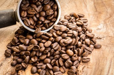Kavrulmuş Kolombiyalı kahve çekirdekleri ahşap bir masa yerleştirilen.