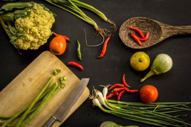 Young spring vegetables on black chalkboard from above. Backgrou