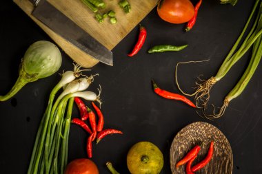Young spring vegetables on black chalkboard from above. Backgrou