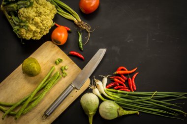 Young spring vegetables on black chalkboard from above. Backgrou