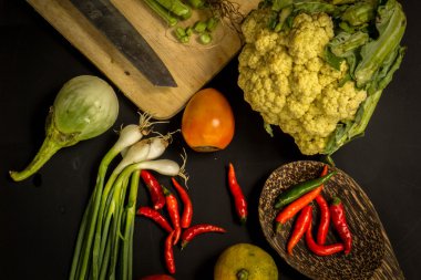 Young spring vegetables on black chalkboard from above. Backgrou